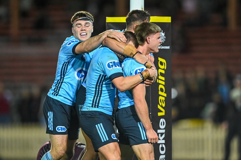 Dellow (left) celebrates a try with his U19 Blues teammates. 